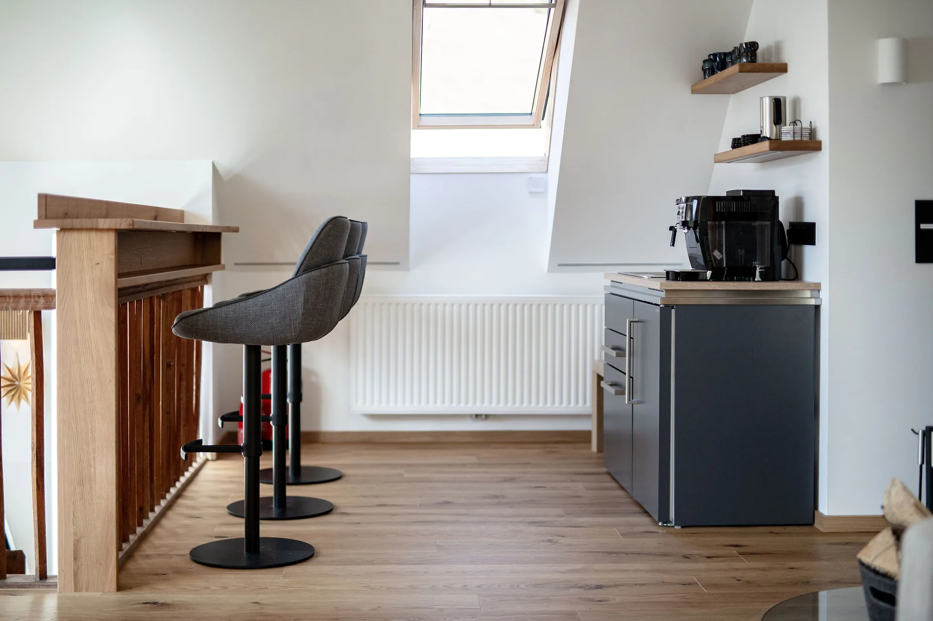 Bar mit Teeküche im Dachgeschoss mit Kaffeemaschine, Geschirrspüler, Kühlschrank und Bergblick.