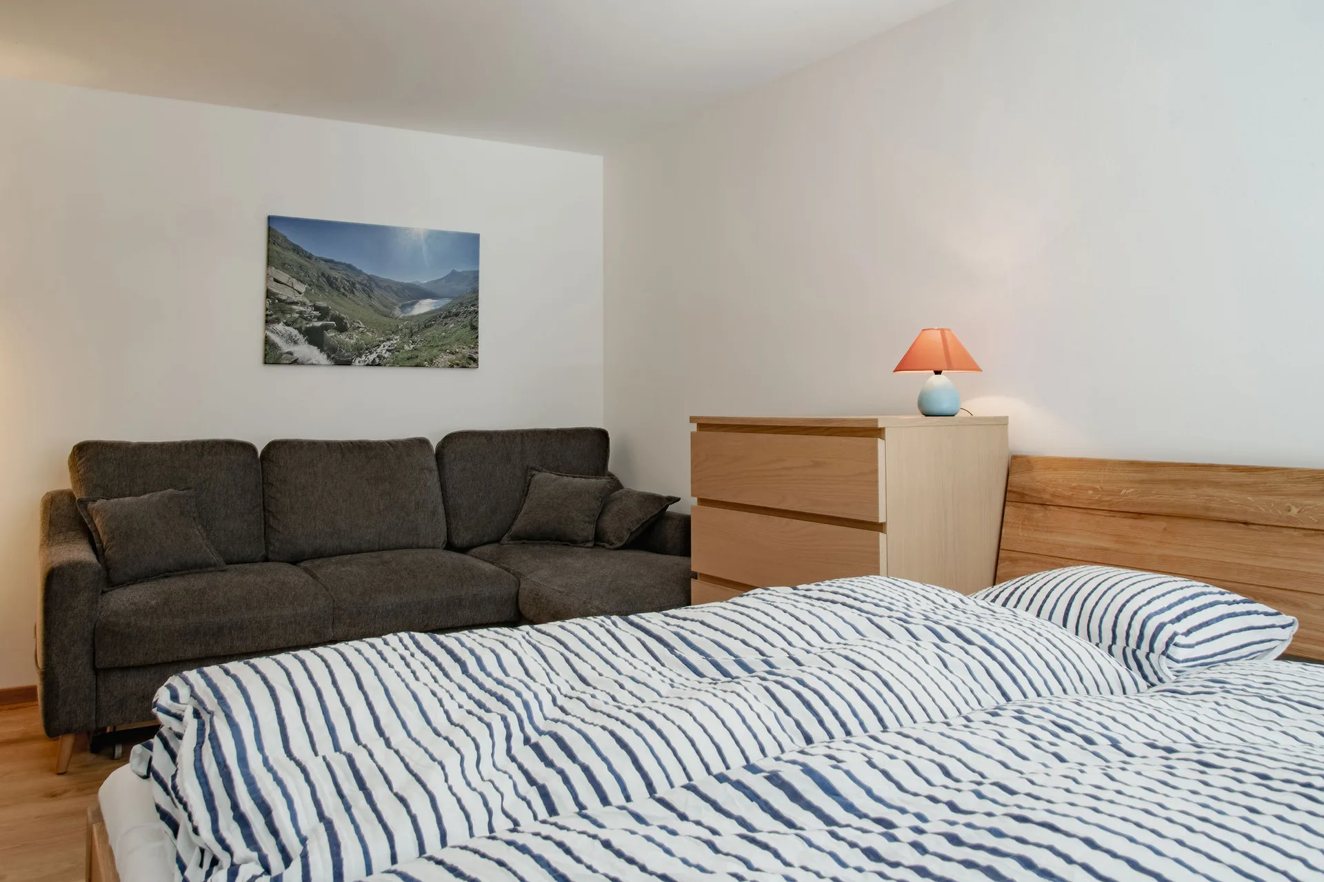 Hofseitiges Schlafzimmer mit 1.60m Doppelbett und Couch im 1. Stock.